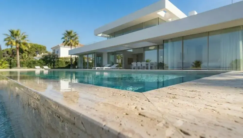 Solado y coronación de piscina en travertino