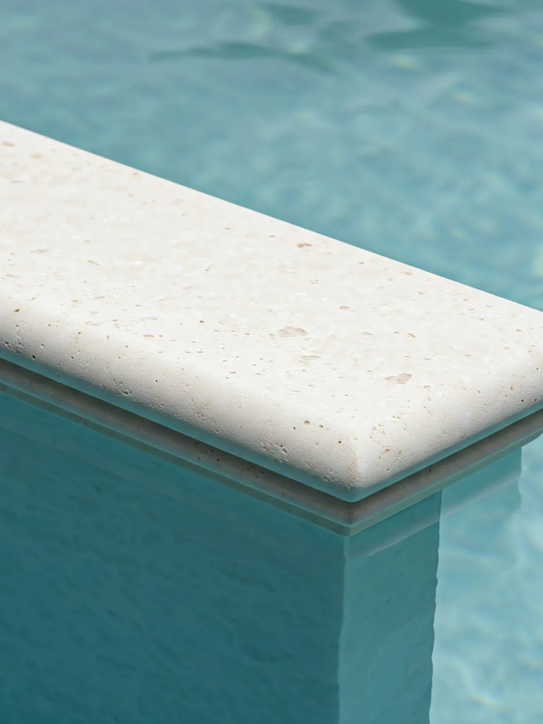Albardilla de piedra con canto redondeado en el borde de una piscina